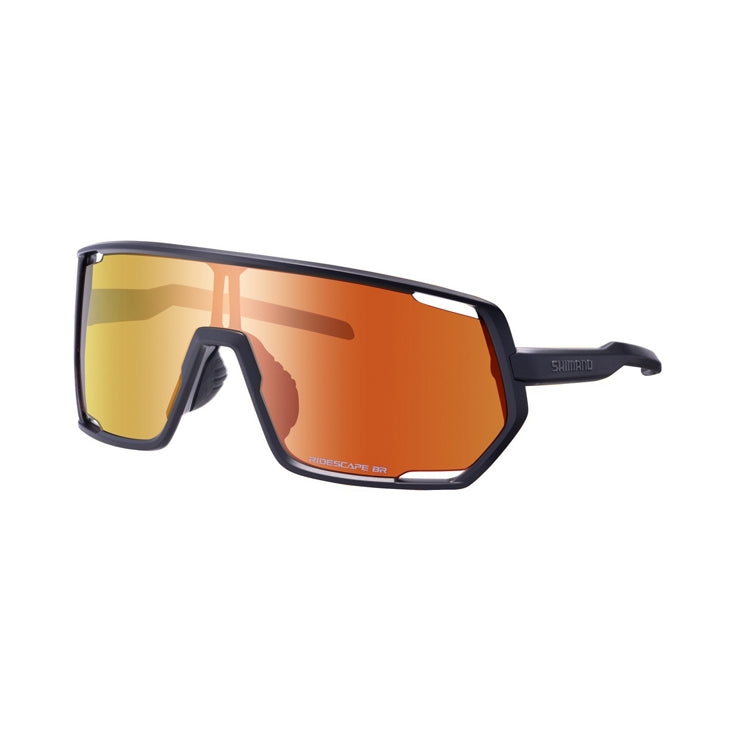 Three-quarter front view of Shimano performance cycling sunglasses featuring a wide shield lens with a mirrored gold-to-orange finish. The dark navy frame surrounds the lens with angular geometric edges, and adjustable nose pads are visible against a light gray background.