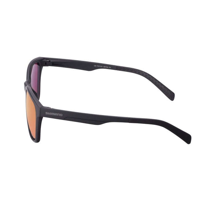 Black Shimano sport sunglasses with a matte black full-rim frame and mirrored bronze-gold lenses, shown from front and side angles on a light gray background. The rectangular lens shape features slightly rounded corners, with Shimano branding on the temple and textured temple tips for grip. The reflective lenses have a subtle pink-purple tint around the edges.