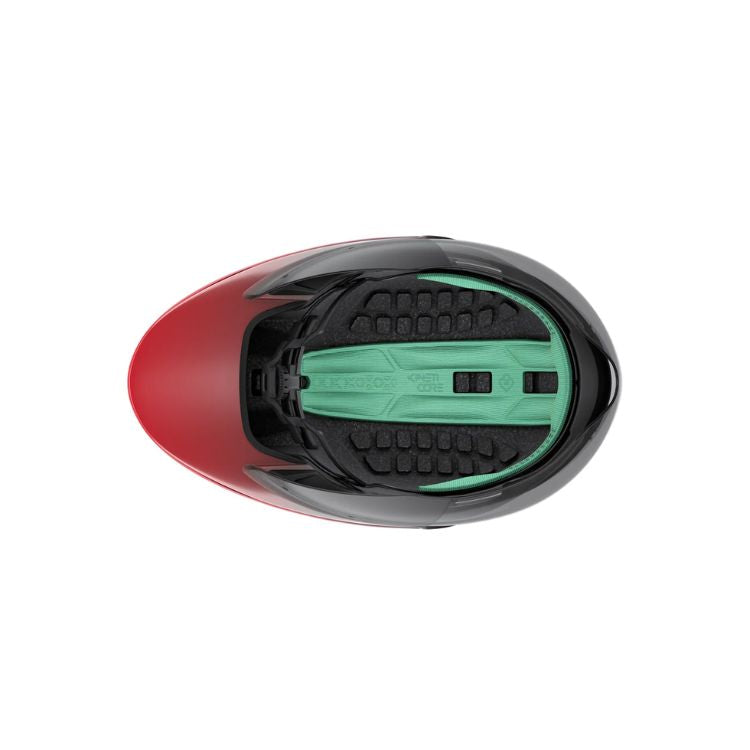 Top-down view of an aerodynamic cycling helmet showing the interior. The helmet features black foam padding and a mint-green central retention and support system running from front to back. The outer shell has a matte black-to-red gradient finish, with the red section visible at the front. The helmet is displayed against a light gray background.
