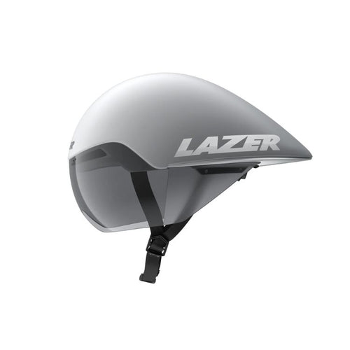 Side view of an aerodynamic cycling time-trial helmet in a matte white and silver finish. The helmet features an extended teardrop-shaped rear profile, an integrated tinted visor covering the eye area, and an adjustable black chin strap. The brand name “LAZER” appears in large silver lettering on the side. Shown against a light gray background.