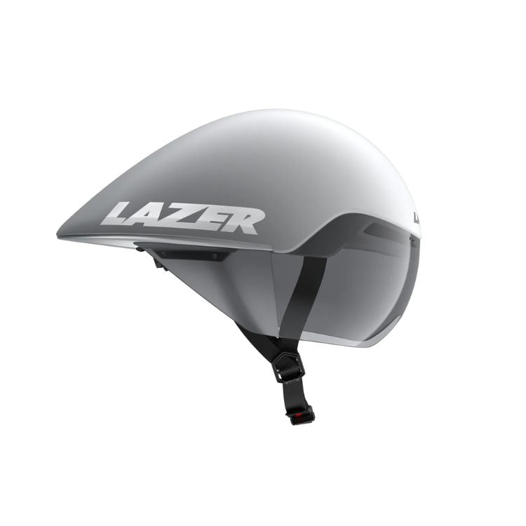 Side view of an aerodynamic cycling time-trial helmet in a matte white and silver finish. The helmet features an extended teardrop-shaped rear profile, an integrated tinted visor covering the eye area, and an adjustable black chin strap. The brand name “LAZER” appears in large silver lettering on the side. Shown against a light gray background.