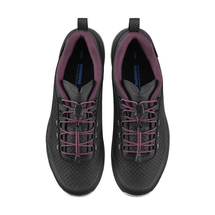 A pair of black cycling shoes with purple accents and laces, top view