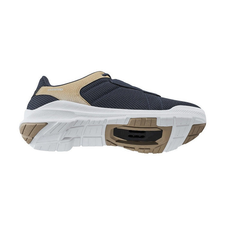 Navy cycling shoe with beige accents, navy laces, Shimano logo, white rubber sole, bottom view
