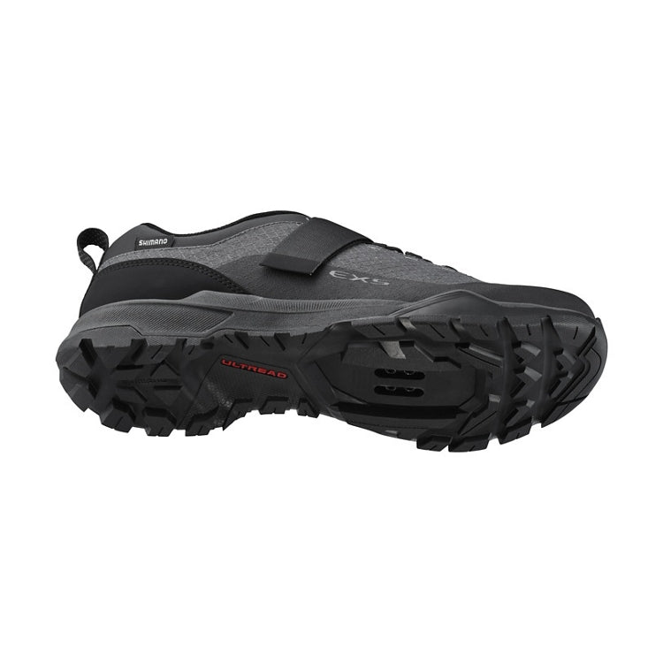 Black shoe with a strap, Shimano logo, black rubber sole, 'Ultread' branding, bottom view