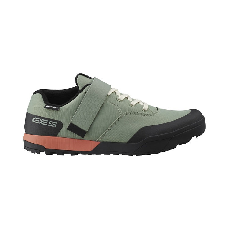 Light green cycling shoe with light green strap and laces, black and orange rubber sole, right view