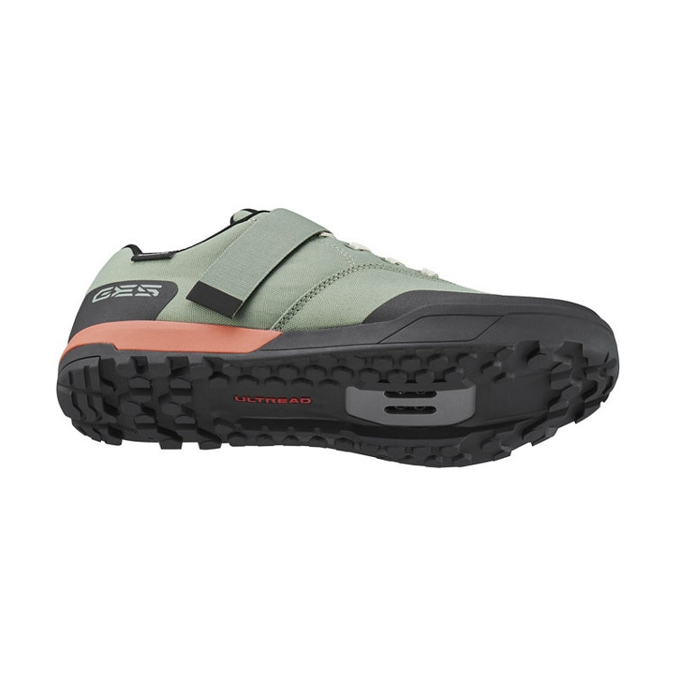 Light green cycling shoe with light green strap and laces, black and orange rubber sole, 'Ultread' branding on sole, bottom view