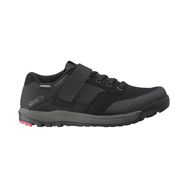 Black shoe with black strap and lace, black and red rubber sole, right view