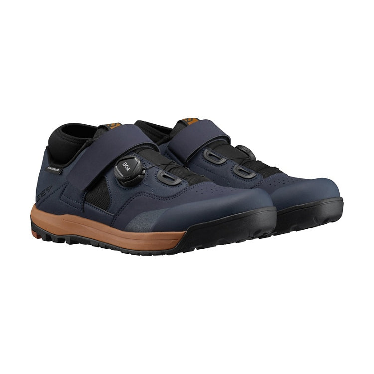 A pair of midnight navy shoe with tan and black sole, one black BOA dial on each side and navy strap, right view