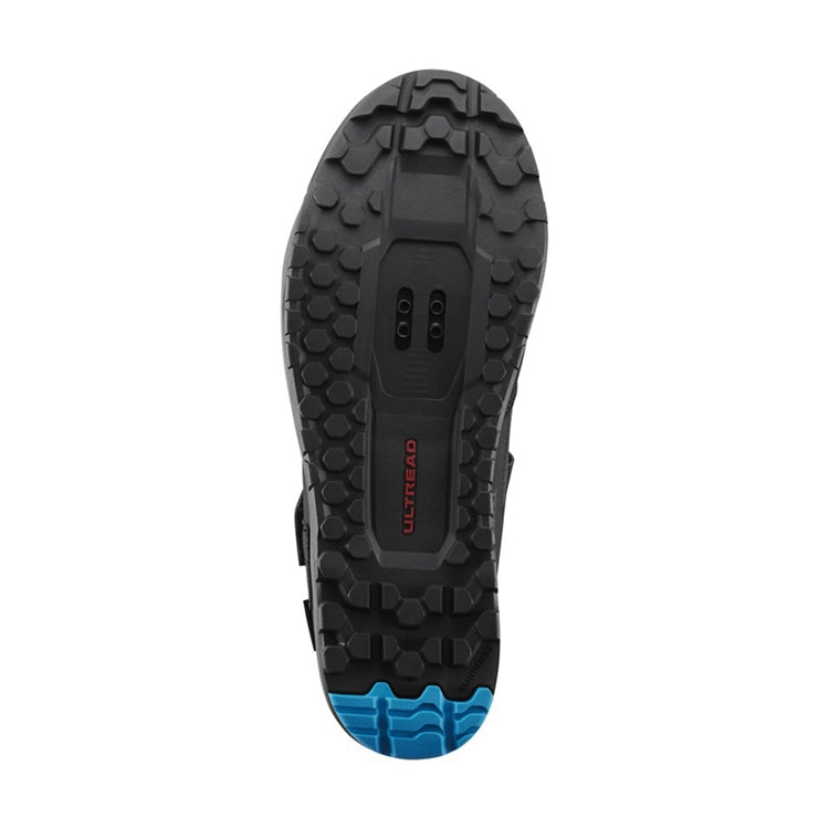 Close up of black rubber sole with blue tip, SPD cleats, 'Ultread' branding, bottom view