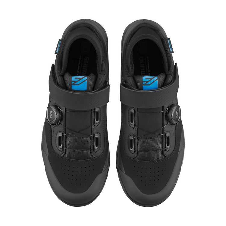 A pair of black shoes with blue accent, one black BOA dial on each side and black strap, top view