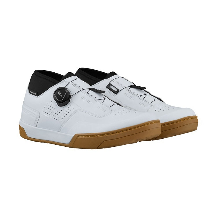 A pair of white cycling shoe with tan sole and black BOA dial, right view