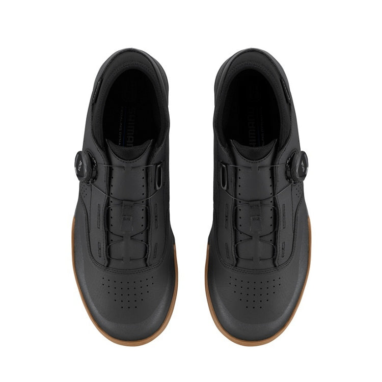 A pair of black cycling shoes with tan sole and black BOA dial, top view