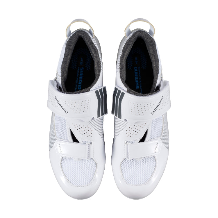 A pair of white cycling shoe with black stripes with Shimano logo on strap, top view